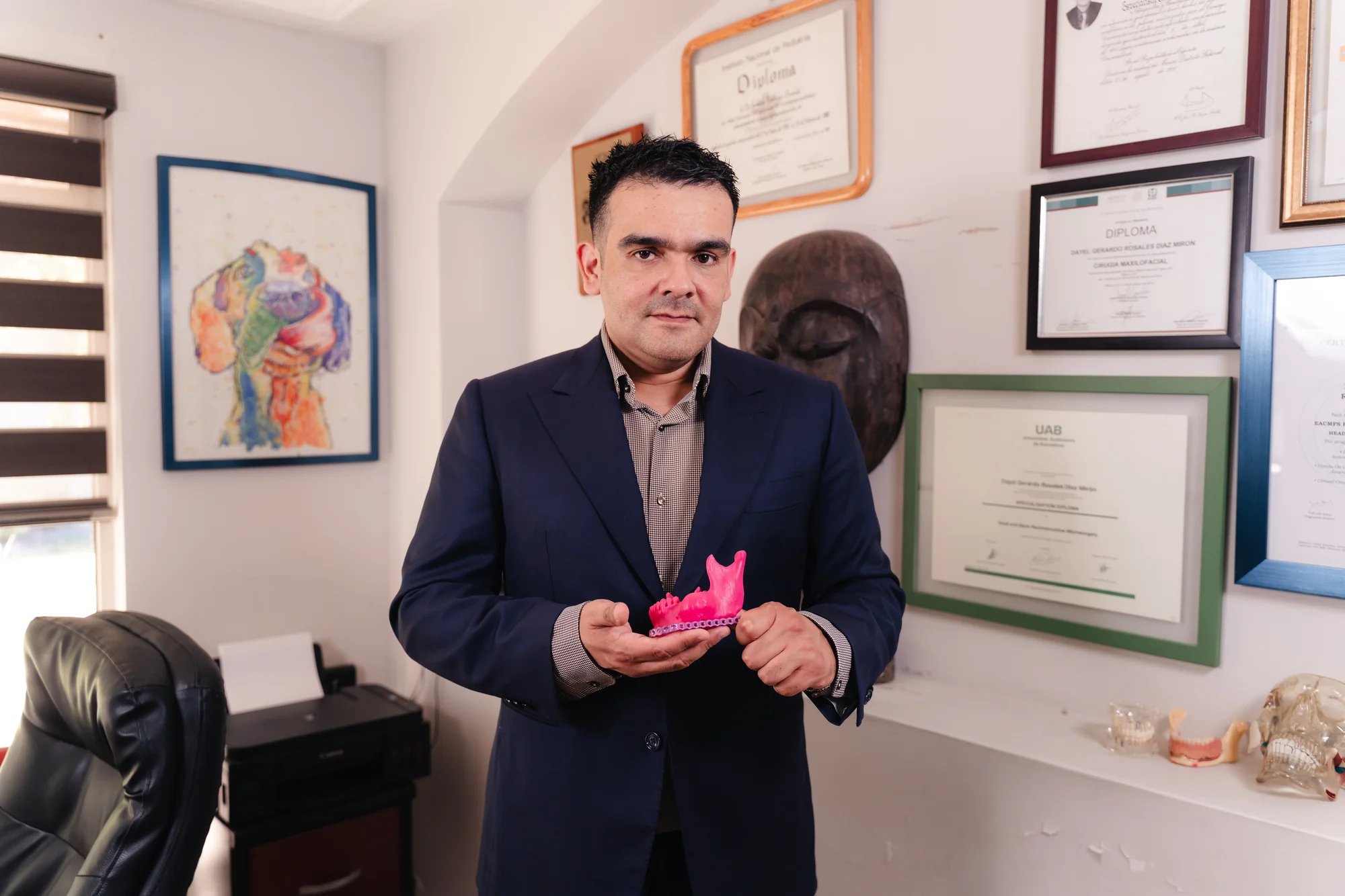Dr. Dayel Rosales en su consultorio con un modelo maxilofacial